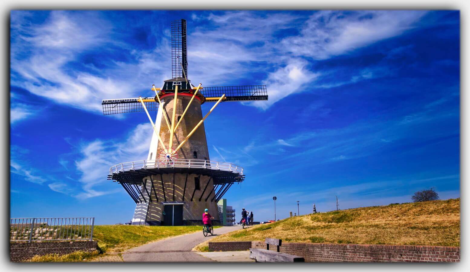 Holland Windmuehle Vlissingen Zeeland Niederlande Radfahrer blauer Himmel 02